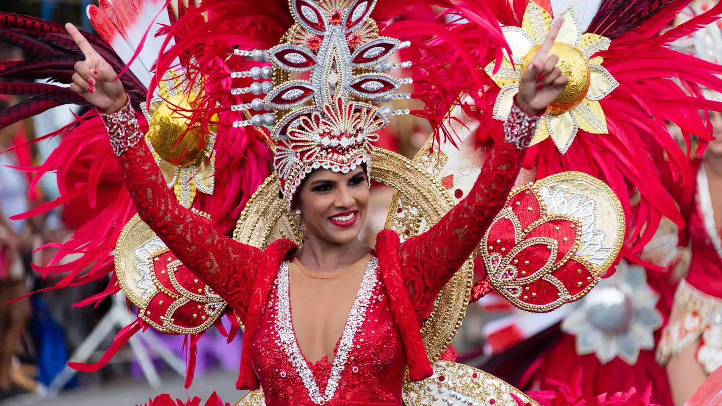 A women in a red costume performs in the carnival of Aruba in Oranjestad