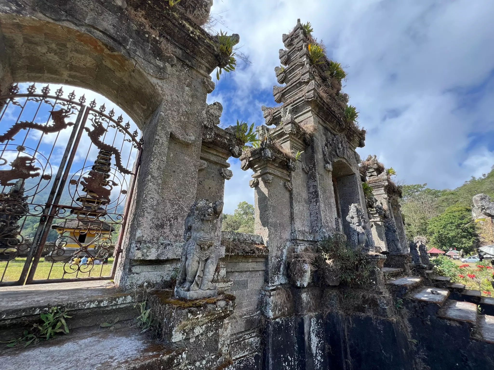 Stone stairs to a temple, with visitors visible through a gate