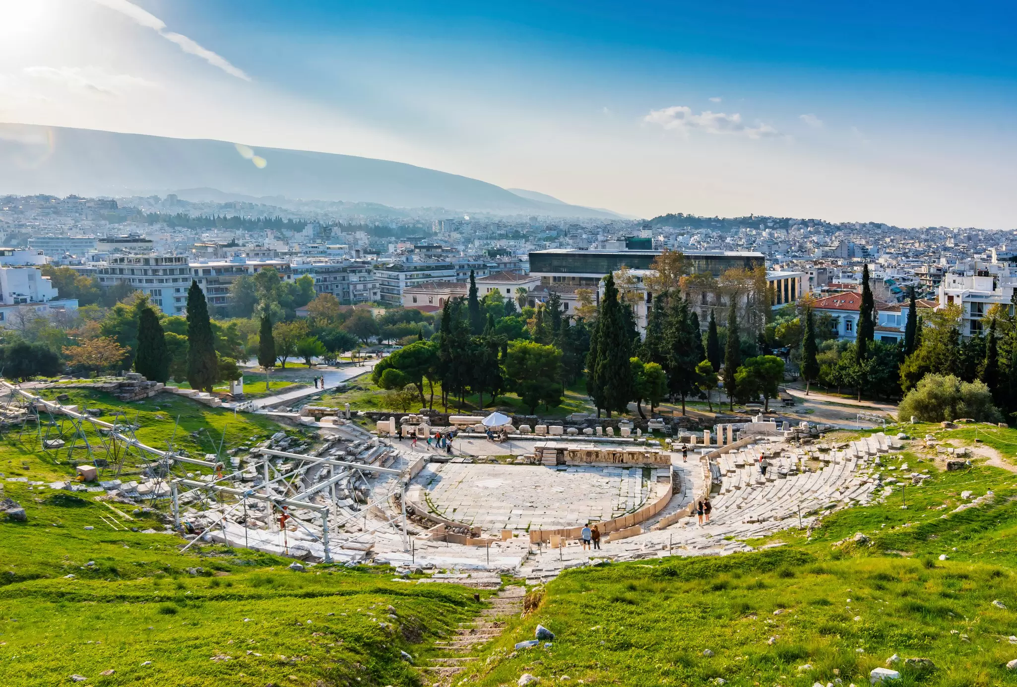 People are visiting The Theatre of Dionysus on Acropolis Hill of Athens.