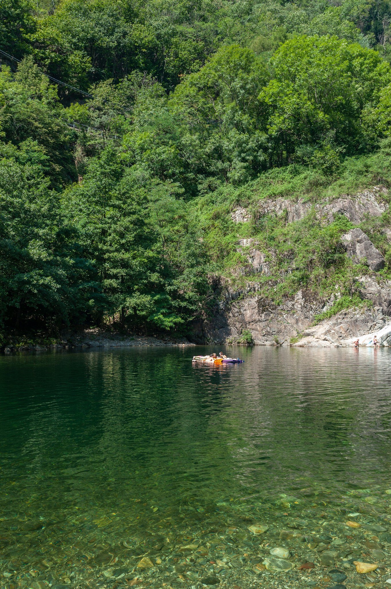 River Cannobino with bathing tourists near the church of Saint Anna in Valle Cannobina near Cannobio.