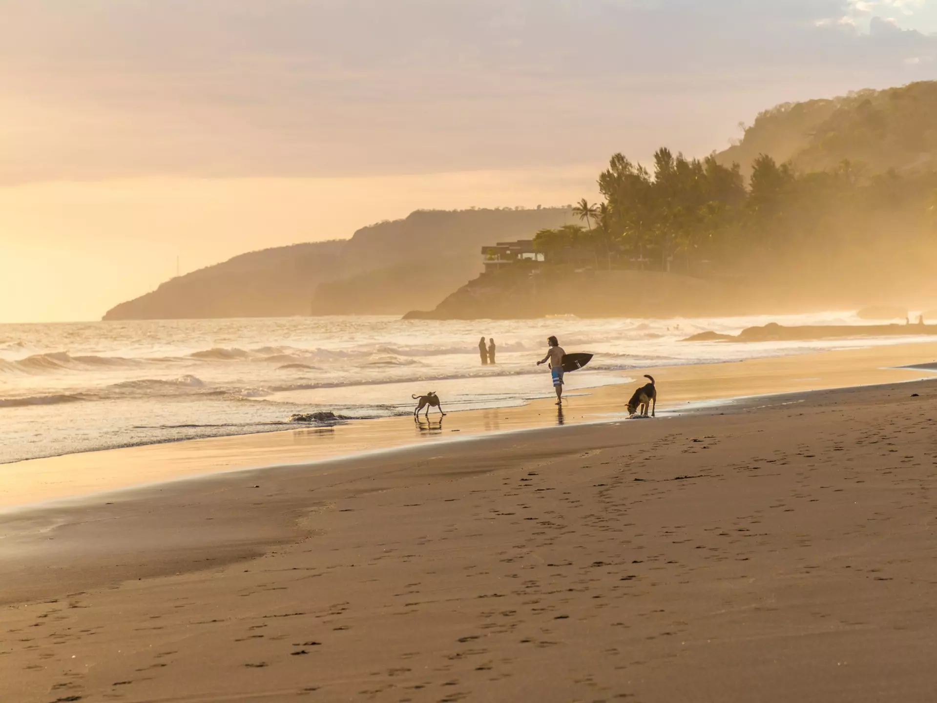 Surfers in the mist on the beach at El Zonte in El Salvador. Chrispictures/Shutterstock