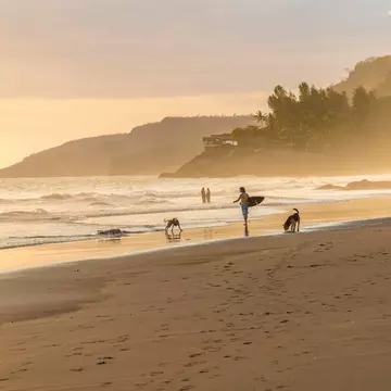 Surfers in the mist on the beach at El Zonte in El Salvador. Chrispictures/Shutterstock