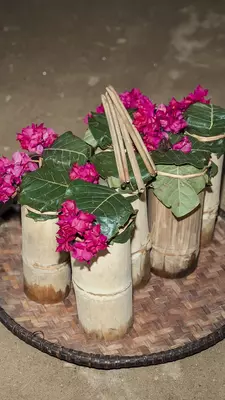 A tray of bamboo pitchers with bougainvillea.