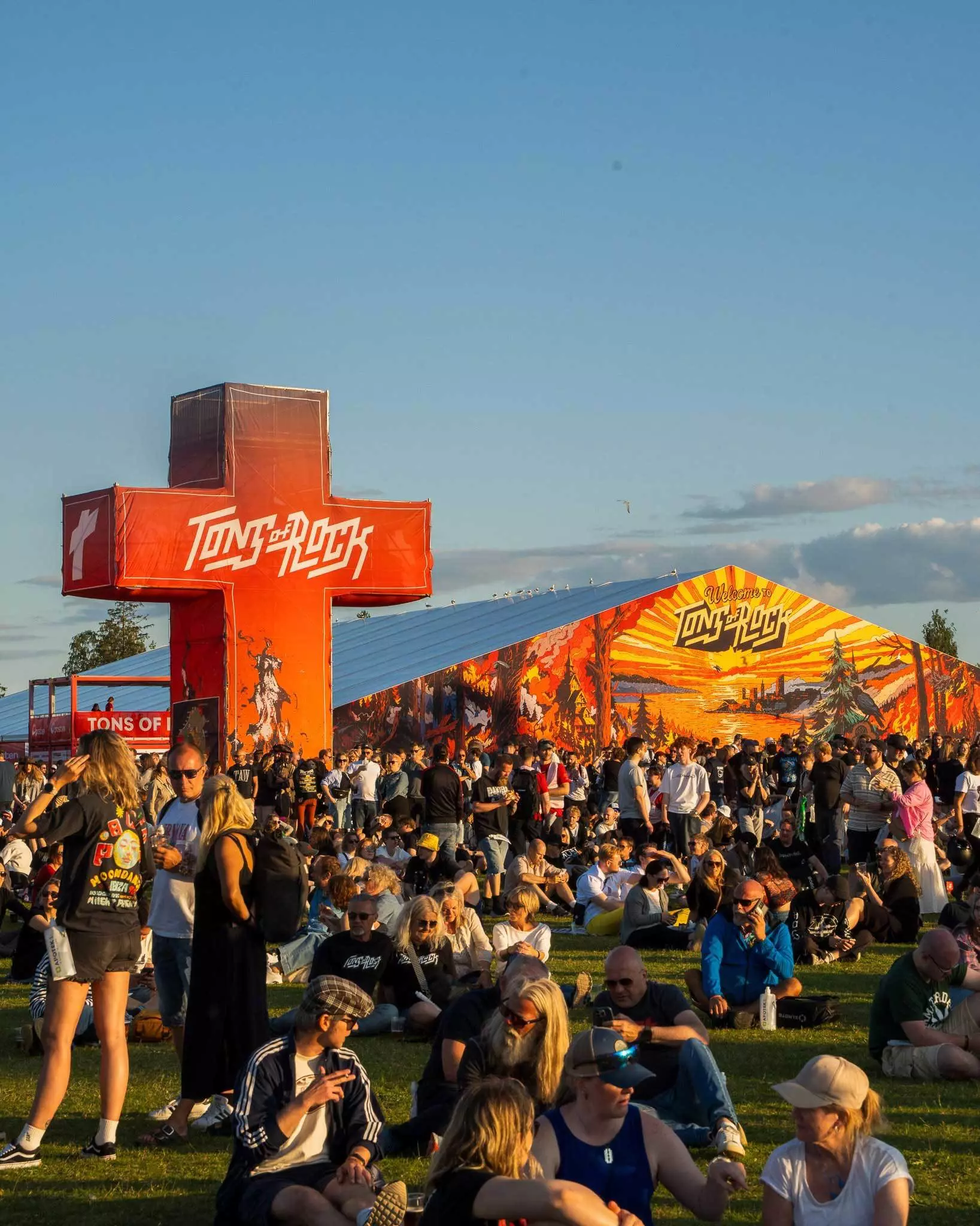 People sitting on grass taking a break in the afternoon sun at Tons of Rock