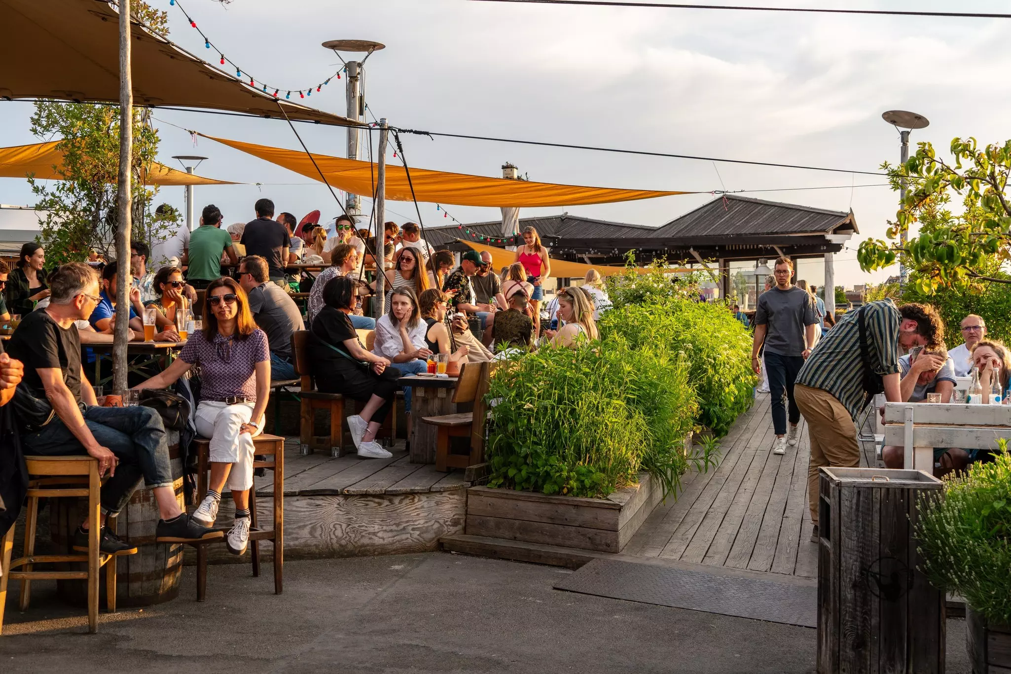 A rooftop bar with lots of people enjoying drinks in the sunshine