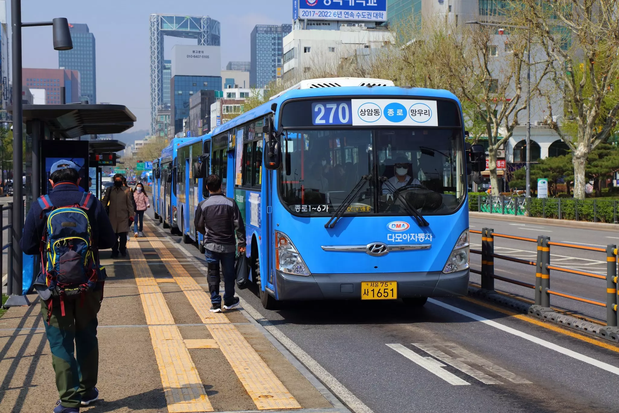 Passengers board city buses on Jong-ro street in Jongno district of Seoul.
