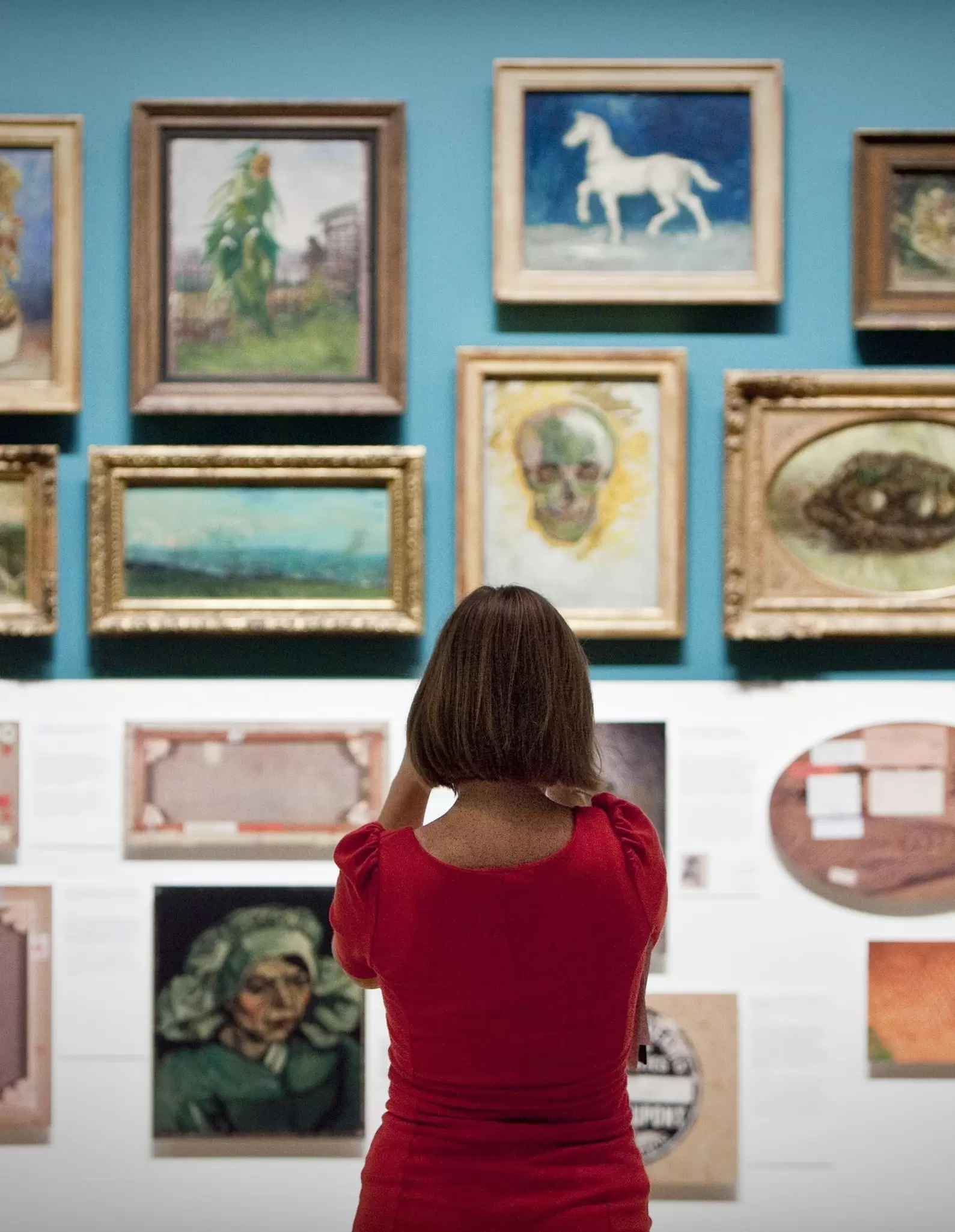 A woman looks at paintings of dutch painter Vincent van Gogh in the Van Gogh Museum in Amsterdam The Netherlands.