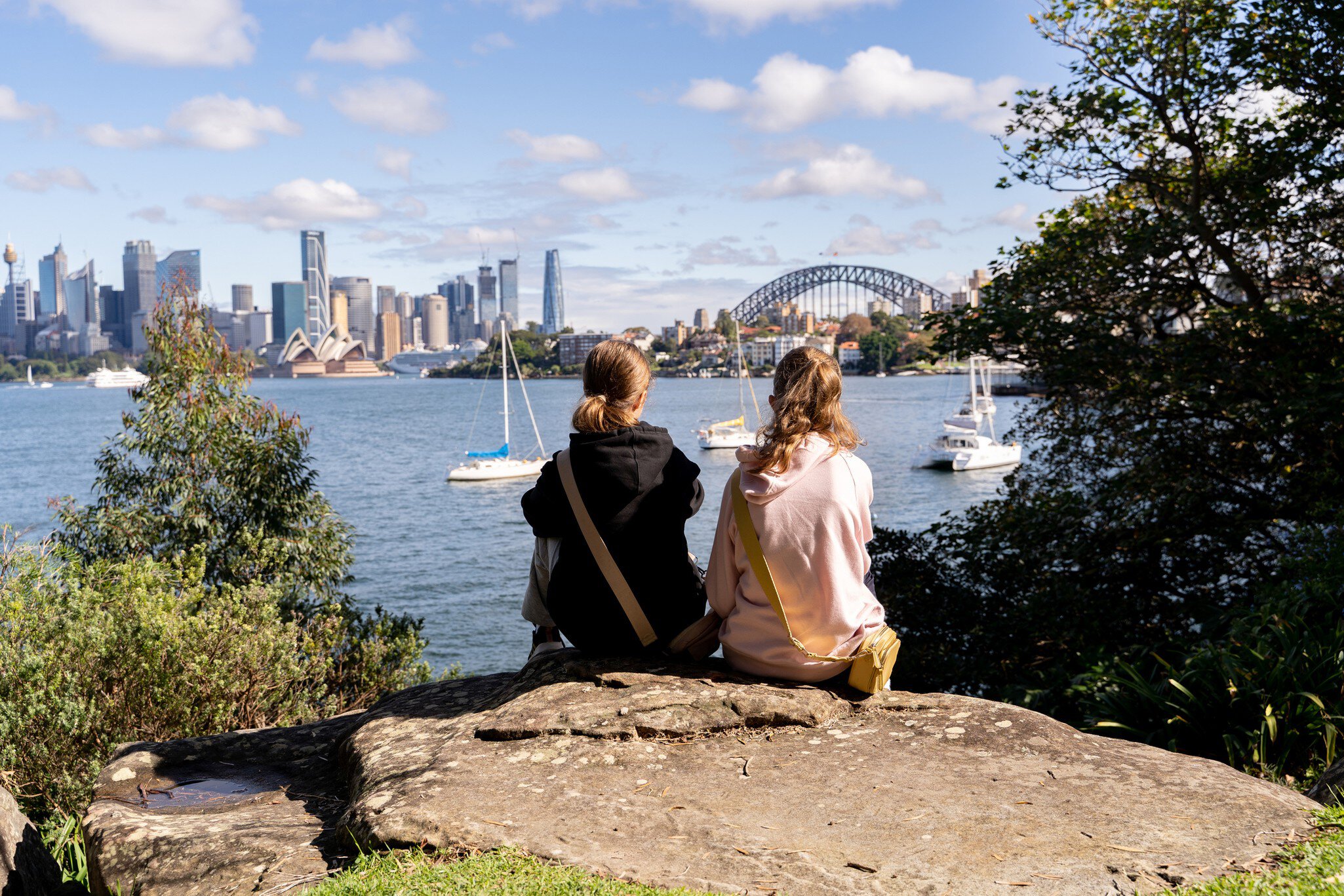 Two girls looking at the Sydney skyline view from Cremorne Point. Sydney, Australia.