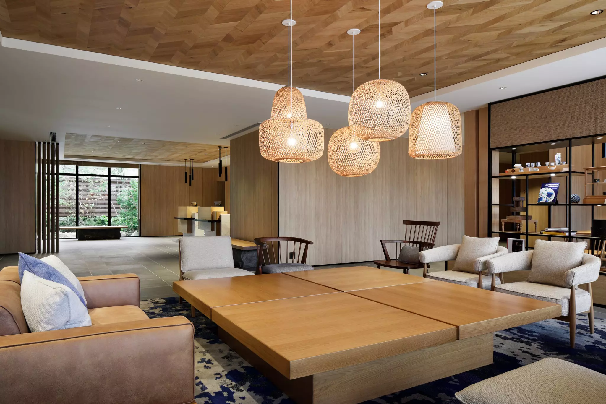 Lobby of a modern hotel with large, low coffee table surrounded by comfortable chairs.