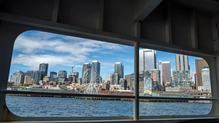 Seattle skyline viewed through the window of a ferry on Elliott Bay in Puget Sound.