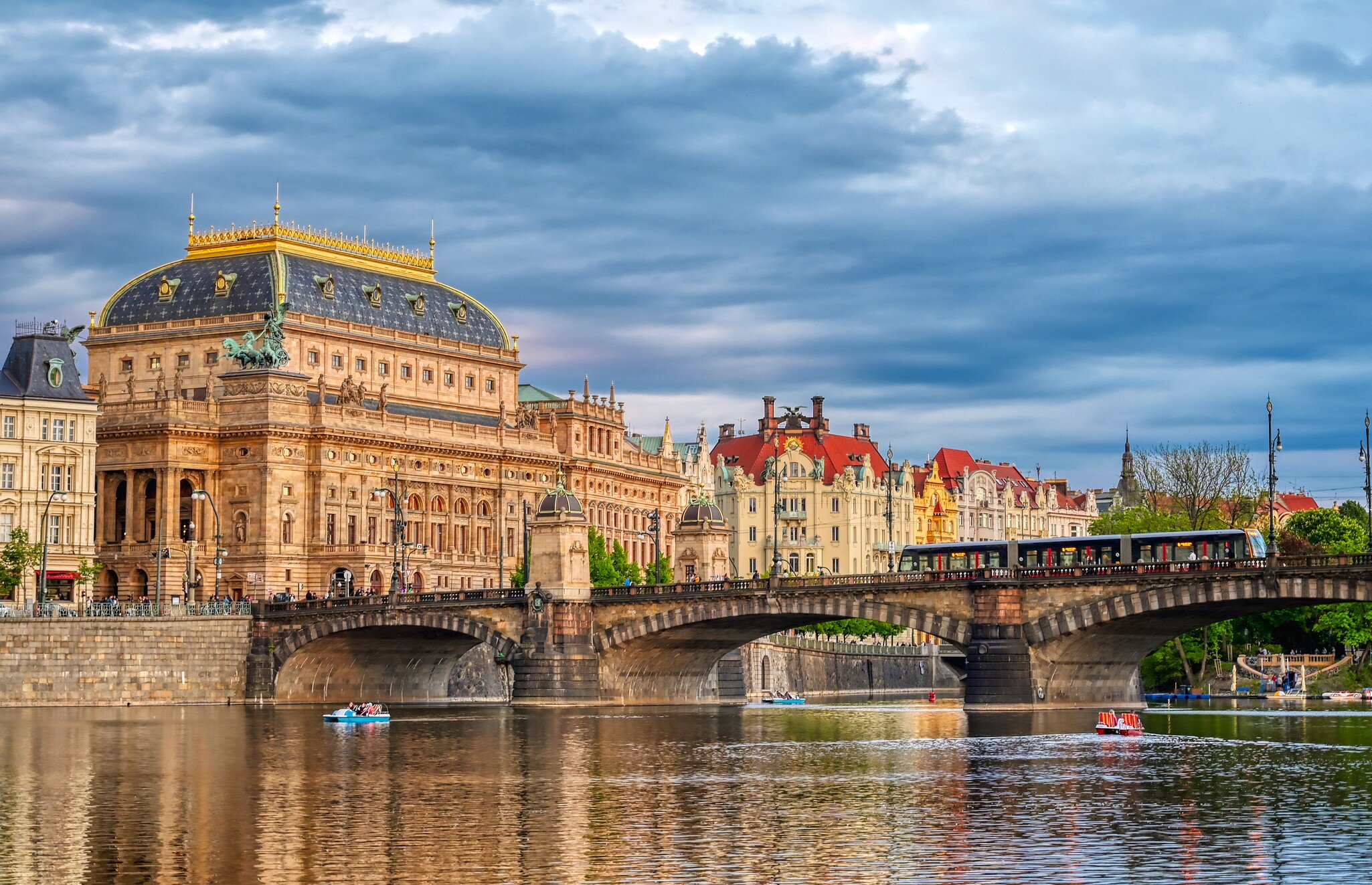 Wide exterior of the National Theatre located in Prague, Czech Republic on the Vltava River. Bridge and blue sky.
