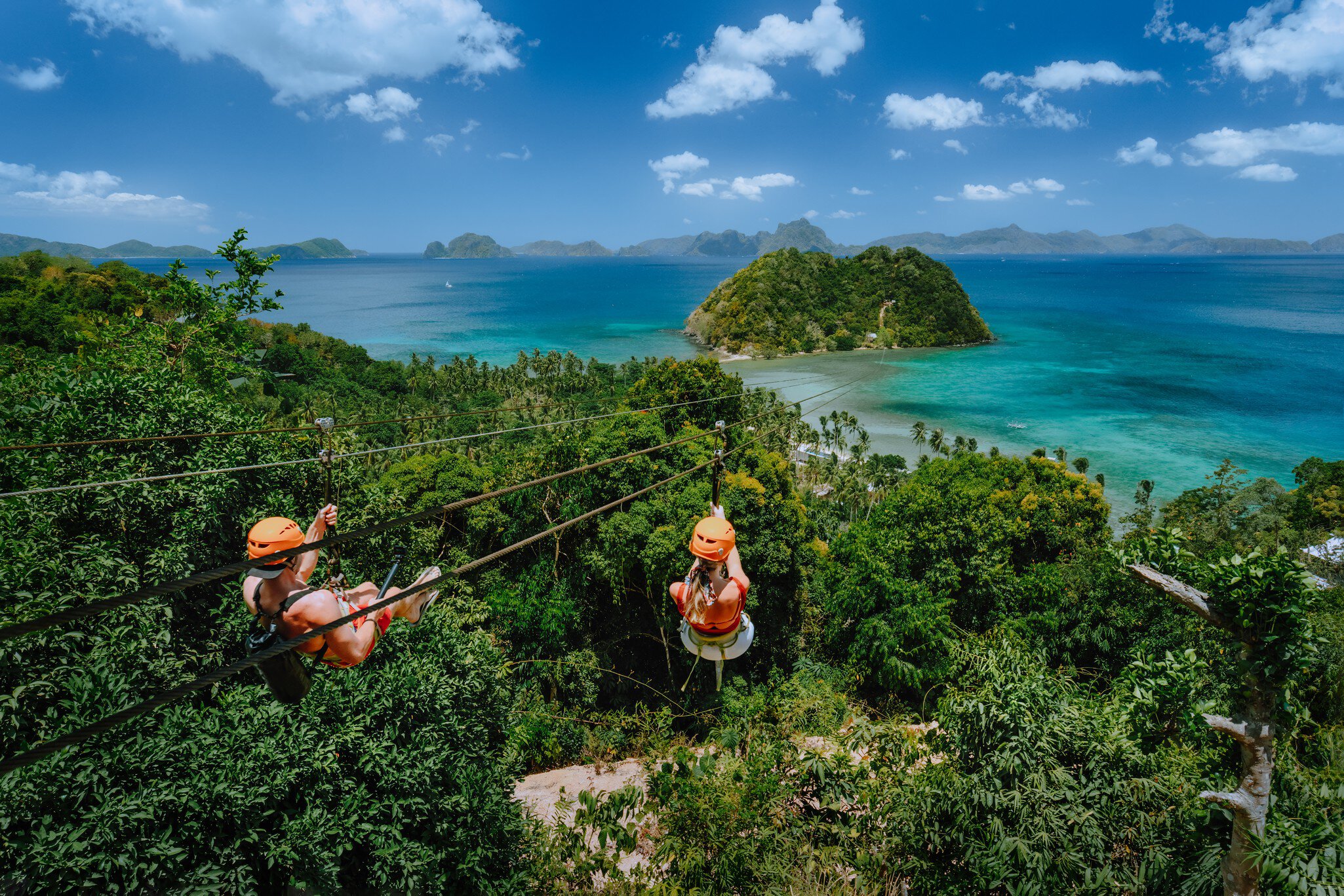Zipline over Las Cabanas Beach with tourist on sunny day with white clouds over sea. El Nido, Palawan, Philippines; Shutterstock ID 1585489660;