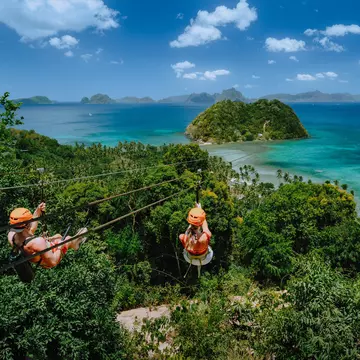 Zipline over Las Cabanas Beach with tourist on sunny day with white clouds over sea. El Nido, Palawan, Philippines; Shutterstock ID 1585489660;