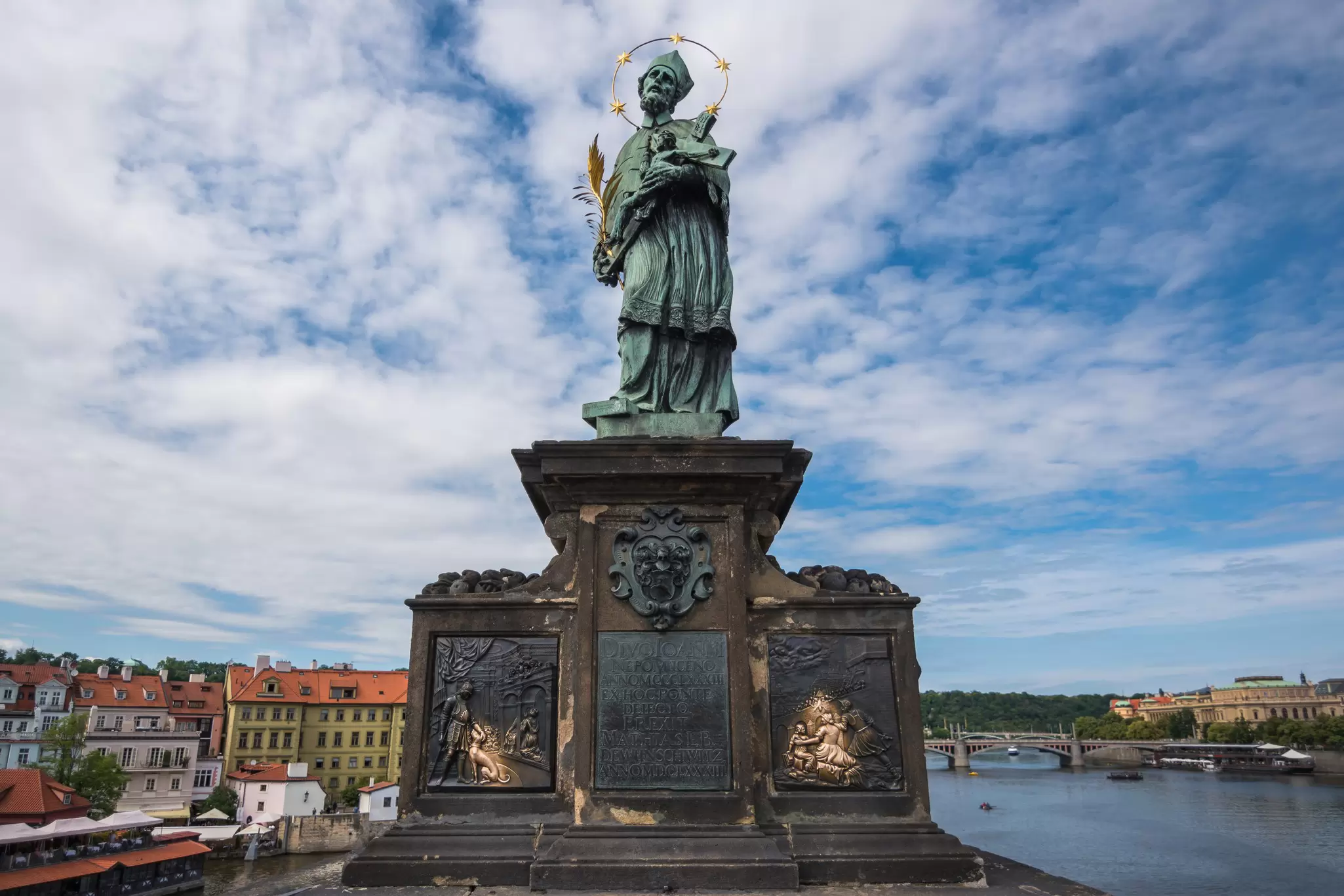 View of the famous statue of John of Nepomuk on Charles Bridge in Prague, Czechia.
