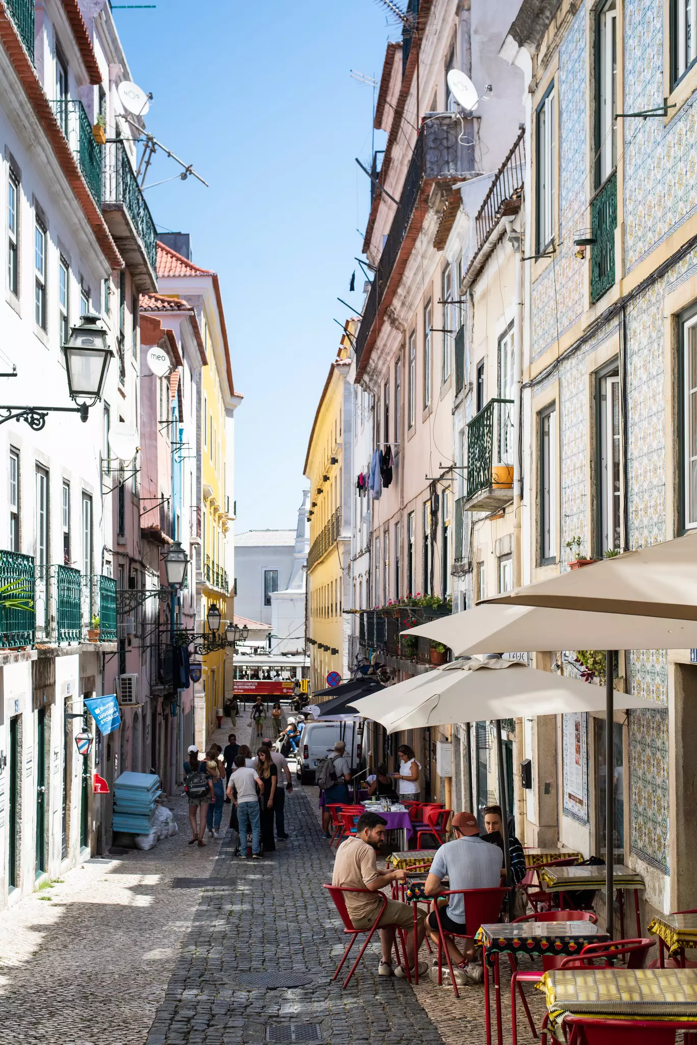 People on a narrow pedestrianized street in a characterful city.