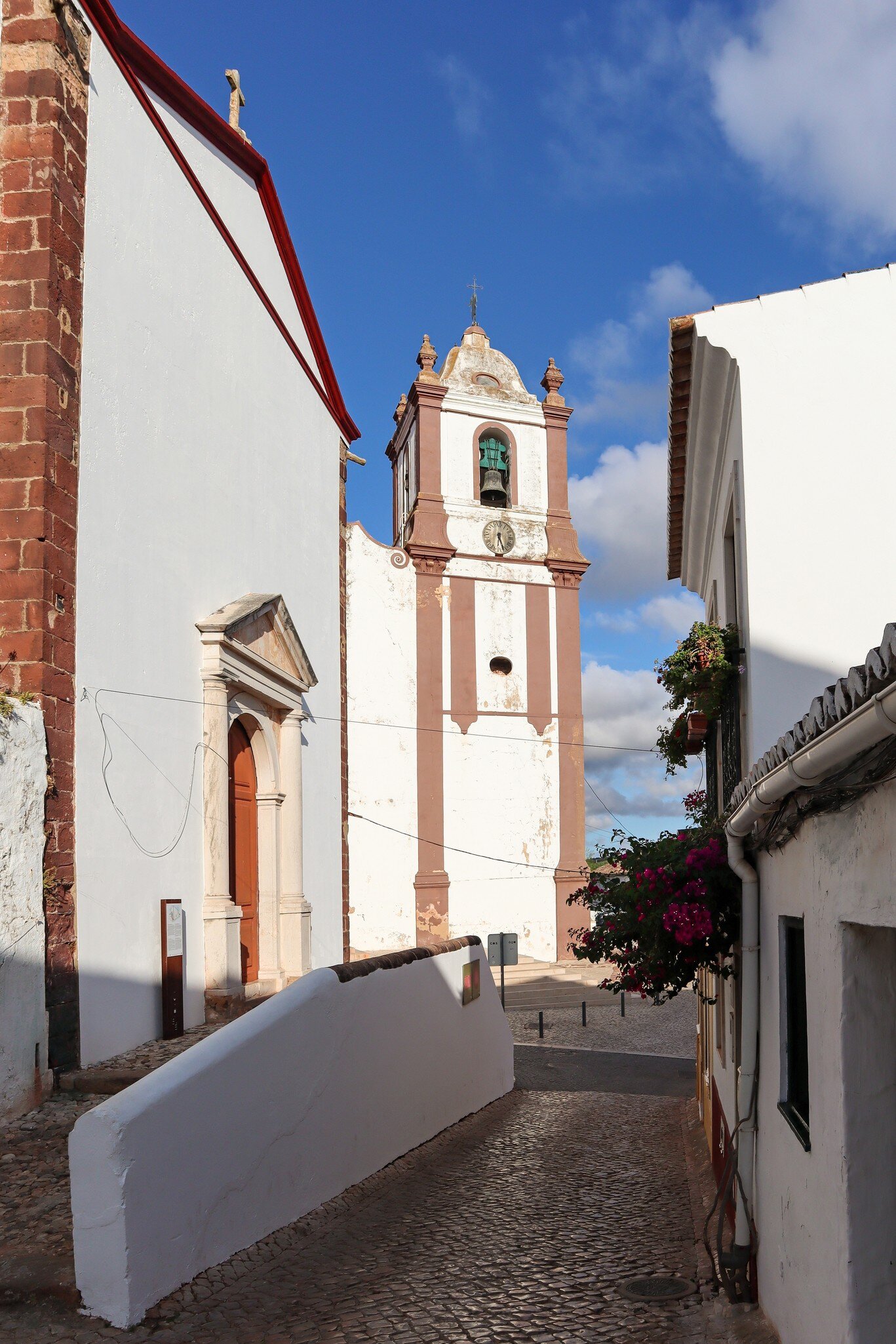 View down an alleyway of the bell tower of the Sé (the cathedral) of Silves, Portugal.