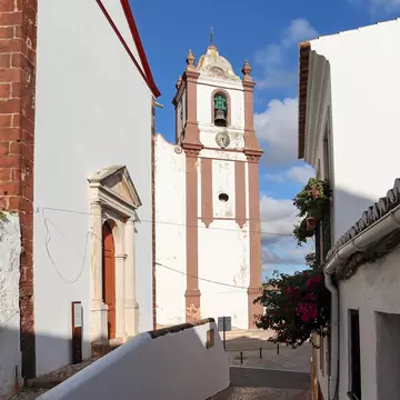 View down an alleyway of the bell tower of the Sé (the cathedral) of Silves, Portugal.