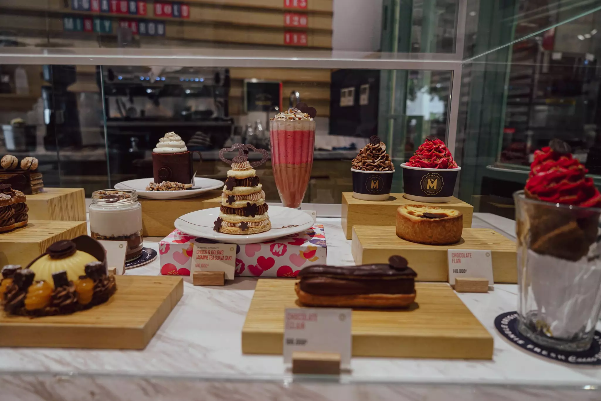 Pastries and other desserts are on display in a glass case at a sweets shop.