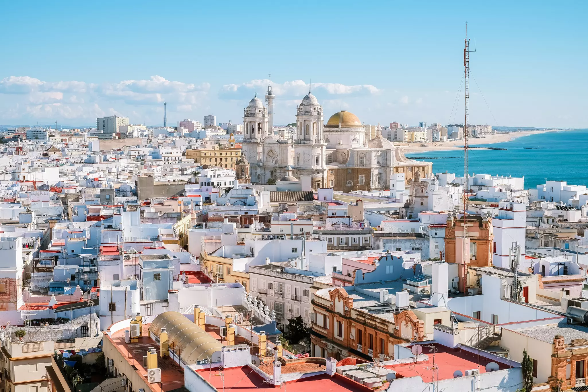 Aerial panoramic view of the old city rooftops and Cathedral de Santa Cruz in the afternoon from tower Tavira in Cadiz, Andalusia, Spain.