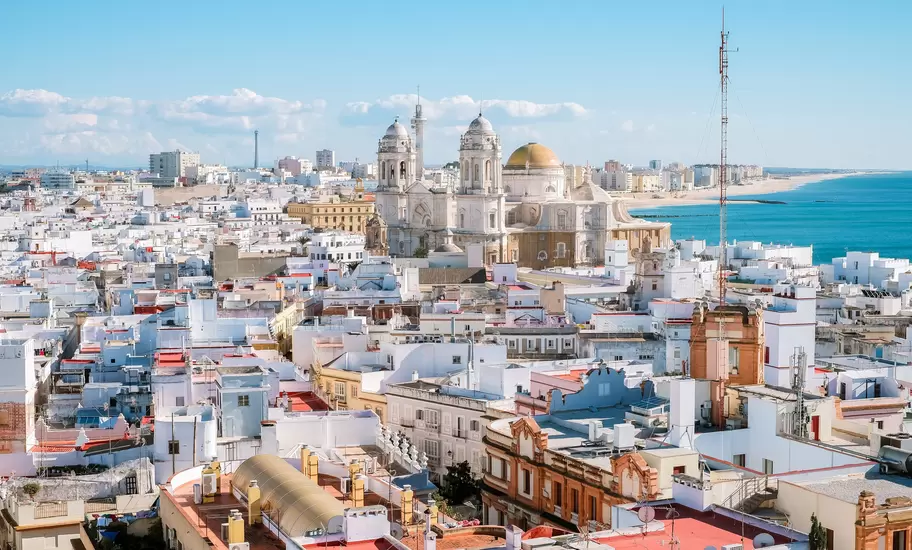 Aerial panoramic view of the old city rooftops and Cathedral de Santa Cruz in the afternoon from tower Tavira in Cadiz, Andalusia, Spain.