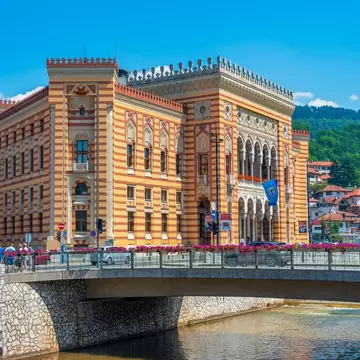 A riverside building with striped brickwork and Moorish designs over the windows.