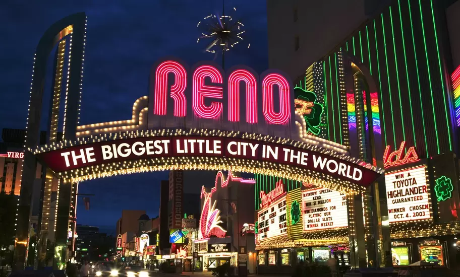 Reno arch in Nevada at night reading 'Reno, The Biggest Little City in the World', with casino neon signs