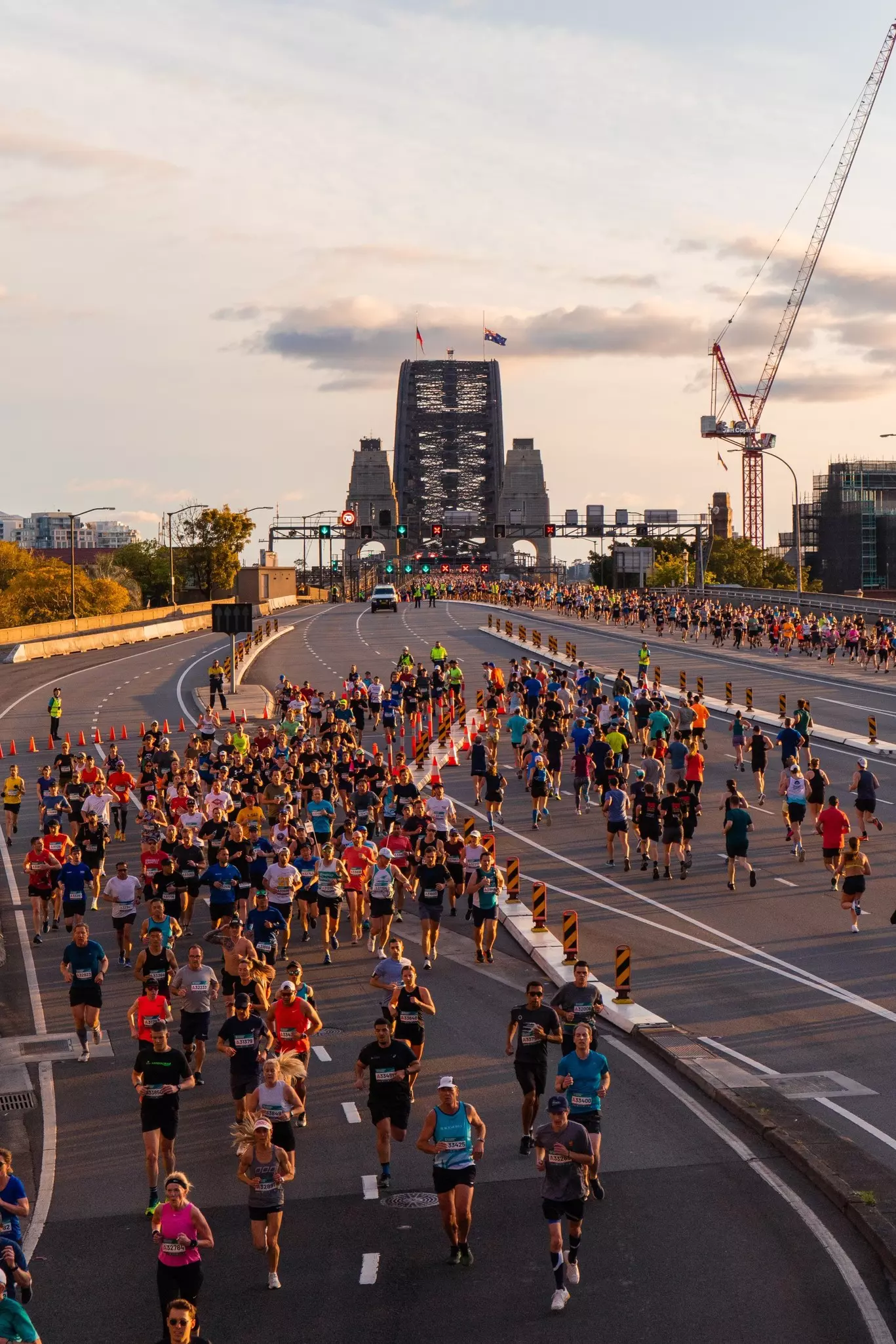 People running on the streets during a race with a bridge behind them