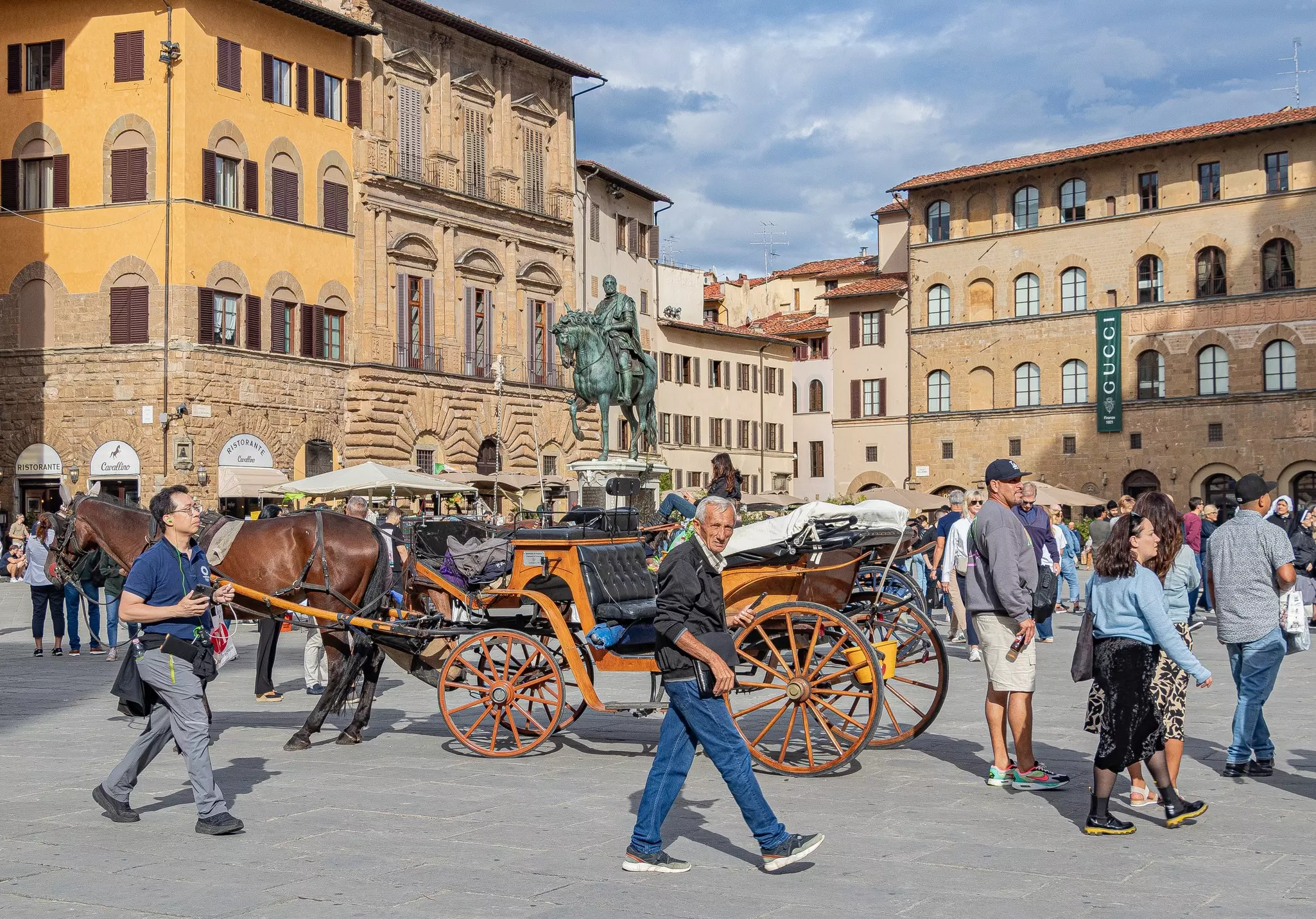 Palazzo Vecchio view with big crowd and horse carriage.