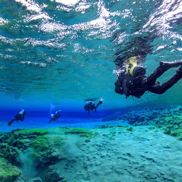 Man underwater diving in Þingvallavatn Lake along Silfra fissure, Iceland