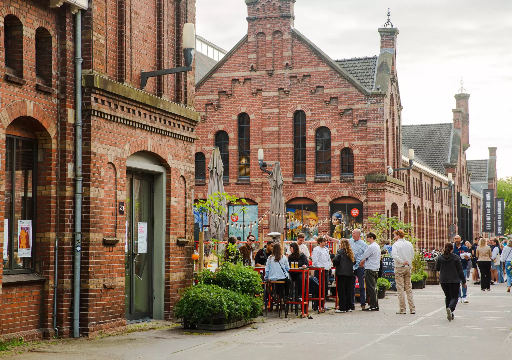 People enjoy drinks outside the onsite brewery of Cultural Park Westergas in Amsterdam, Netherlands.