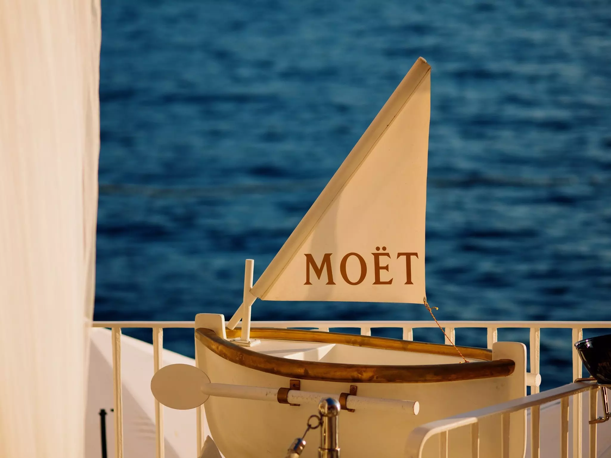 Moet et Chandon champagnes promotion on interior of luxury open-air restaurant on Adriatic sea coast. Valentino cocktail and champagne bar logos on white sun umbrellas. Rovinj, Croatia