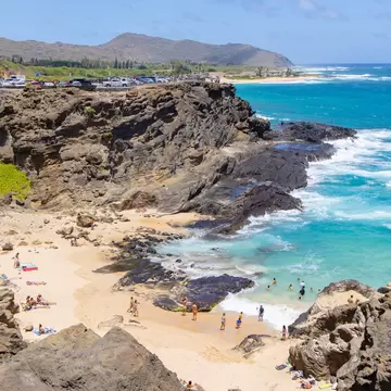 East Coast, Hawaii / USA - August 25 2019: Halona Beach Cove is a small sandy beach surrounded by rocky cove at Oahu southeast, it attracts people for swimming and suntanning while calm tides.