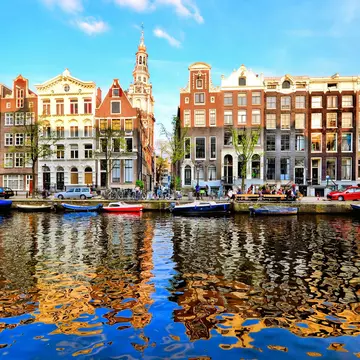 Canal houses of Amsterdam at dusk with vibrant reflections, Netherlands