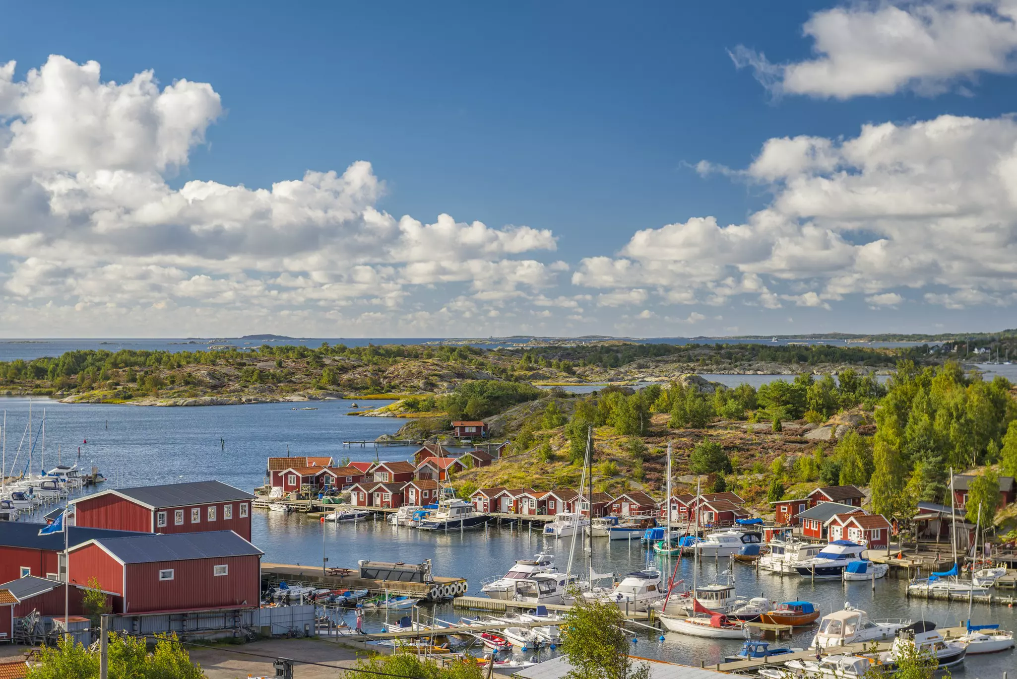 A small harbor on an island lined by red wooden chalets