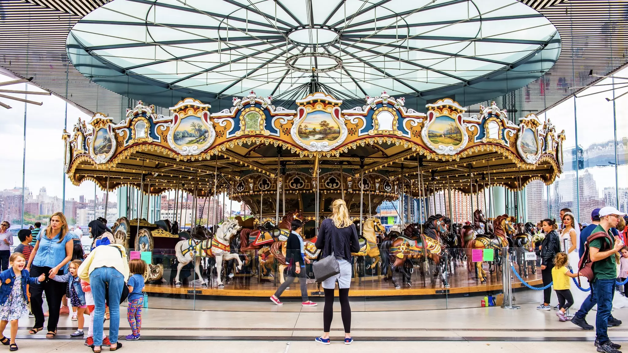 Families having fun at the famous Jane's Carousel in Brooklyn Bridge Park. Brooklyn, New York.