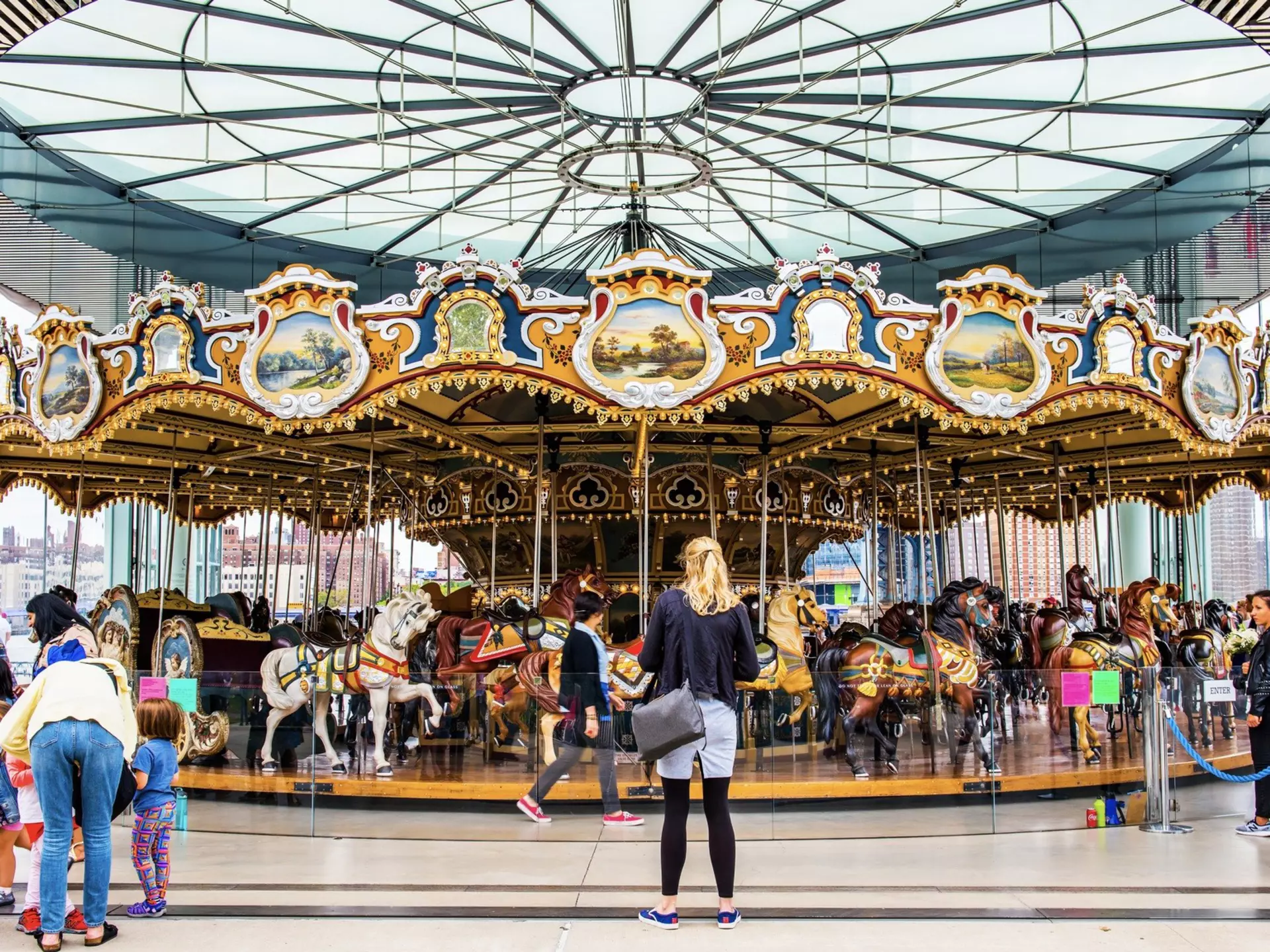 Families having fun at the famous Jane's Carousel in Brooklyn Bridge Park. Brooklyn, New York.