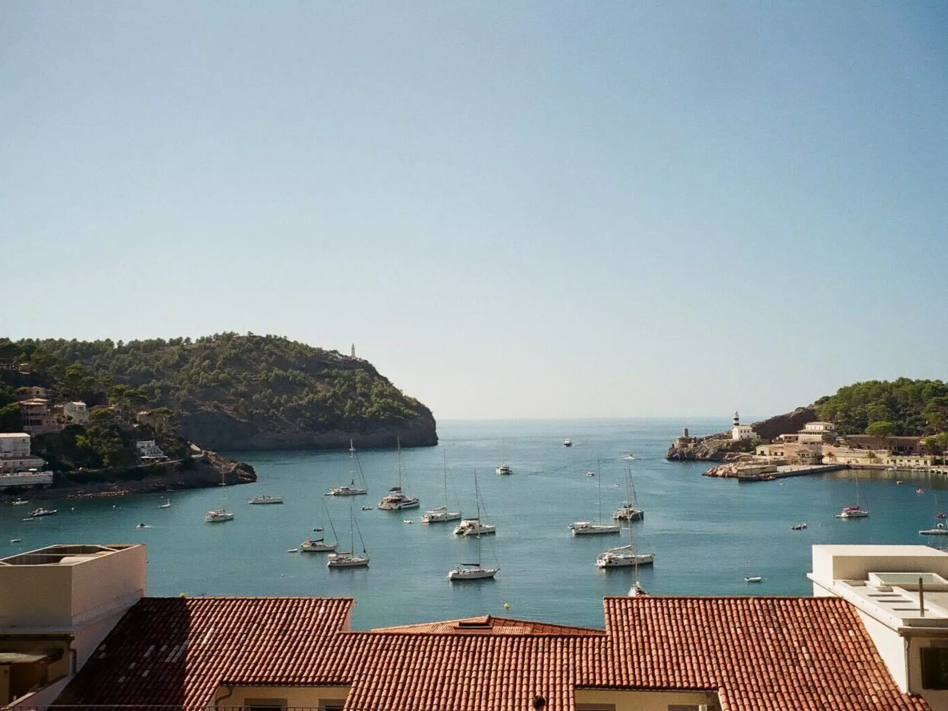 View from window over roof of a hotel and a harbour with boats in Soller, Mallorca