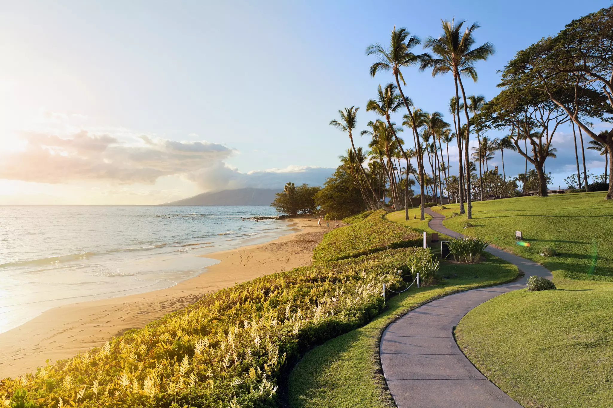 A path between a green lawn and the beach at Wailea in Maui