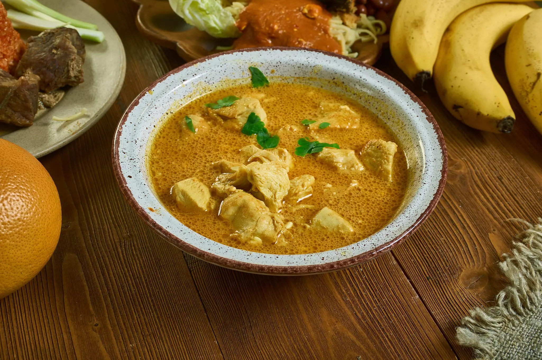 A bowl of traditional groundnut soup in a Ghanaian restaurant.