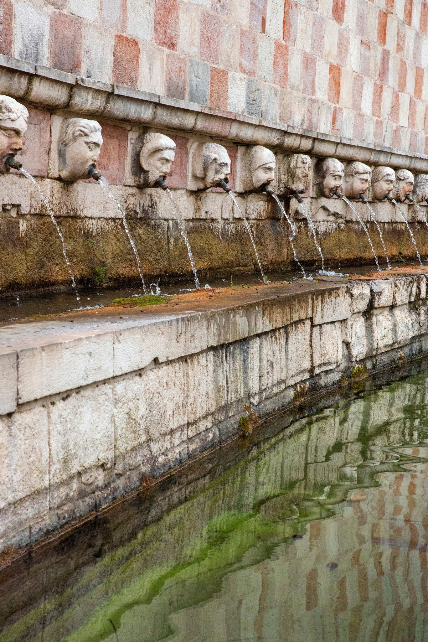 Closeup of the square of the fountain of the 99 spouts located in the historic center of L'Aquila, in Abruzzo, Italy.