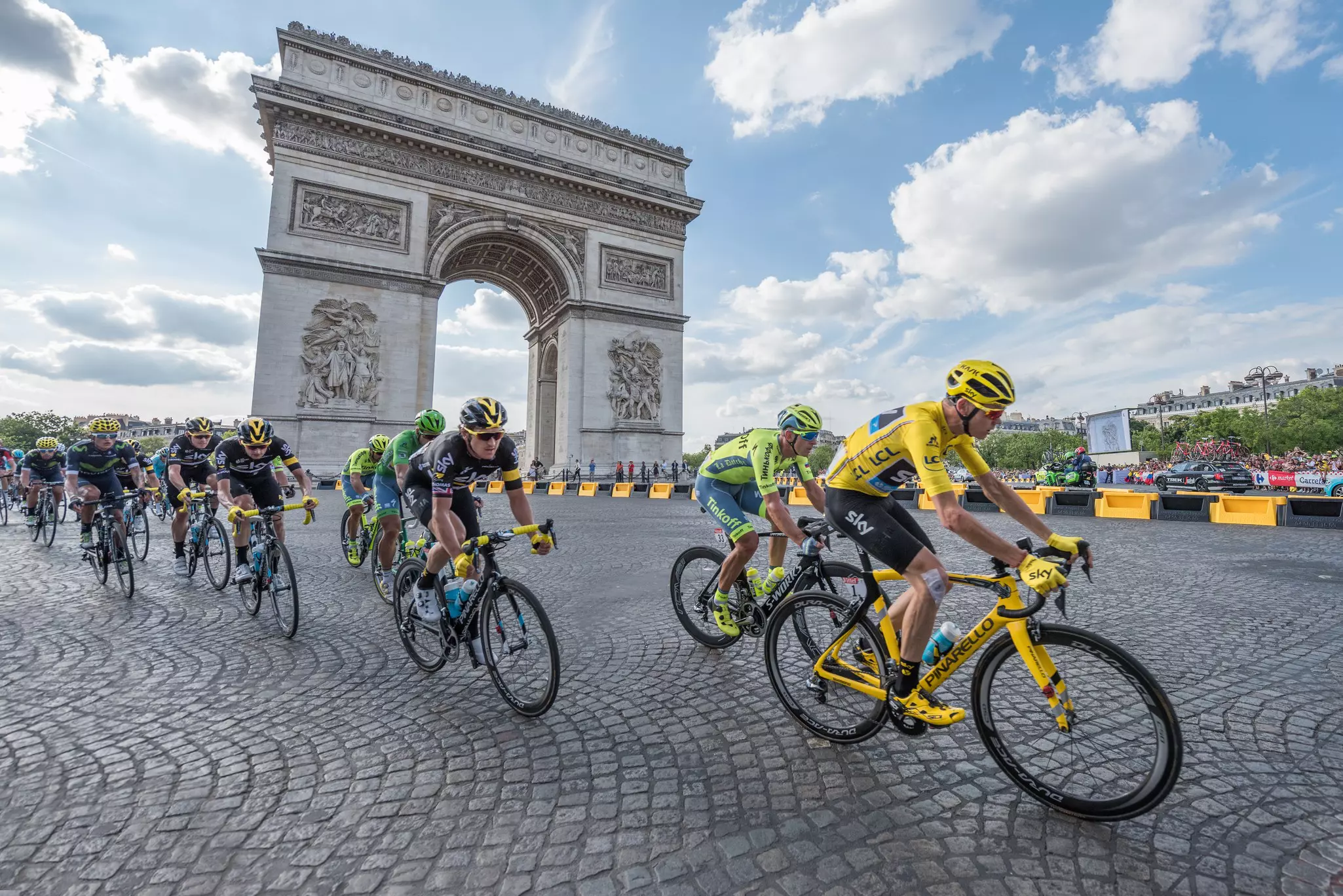 The road racing cyclist Christopher Froome, wearing the leader's yellow jersey in front of Arc de Triomphe during the Tour de France 2016 on the Champs Elysees Avenue.