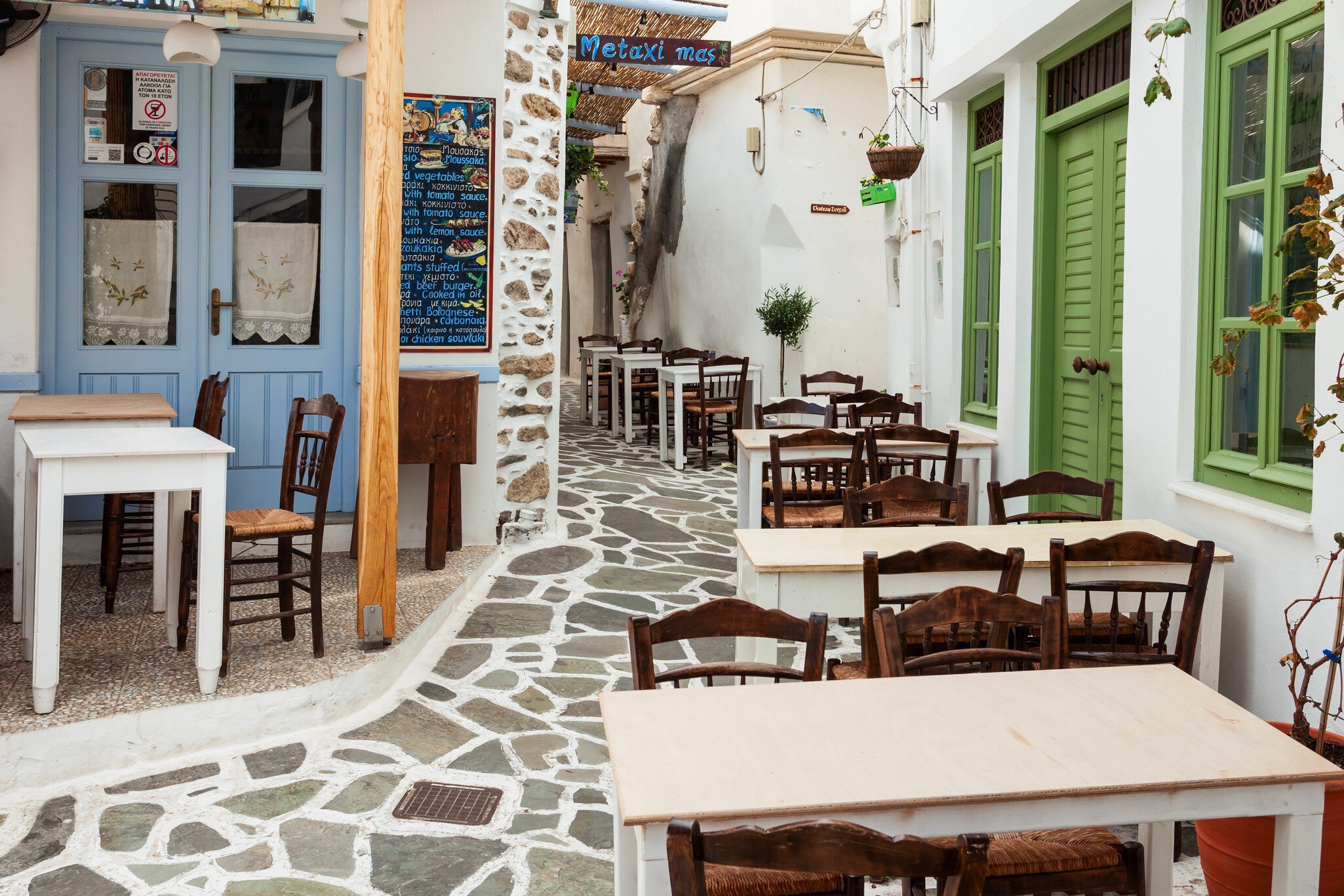 NAXOS ISLAND, GREECE - OCTOBER 24, 2016: Restaurant in Naxos Chora old town, Naxos island in Greece; Shutterstock ID 1946588611; your: Erin Lenczycki; gl: 65050; netsuite: Digital; full: POI