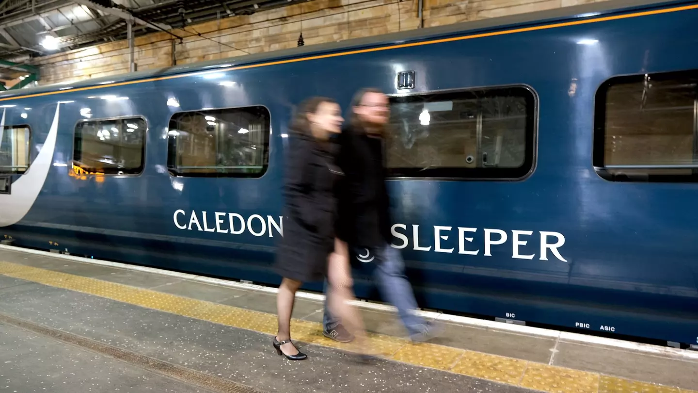 Edinburgh, Scotland - October 31 2019:A couple walk past the Caledonian Sleeper train in Waverley Station, Edinburgh, License Type: media, Download Time: 2025-12-10T17:24:14.000Z, User: rhylton_redventures, Editorial: true, purchase_order: 65050 - Digital Destinations and Articles, job: Lonely Planet , client: wip, other: Rhianydd hylton