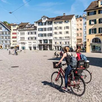Two young ladies ride bicycles through a town square in Zurich.
693239720
Young Adult, Adult, Adults Only, Travel, Switzerland, European Culture, Summer, Famous Place, Women, Building Exterior, Capital Cities, Zurich, Young Women, Day, 20-24 Years, Cycling, Two People, People, Vacations, Town Square, Journey, City, Photography, Outdoors, Horizontal, Only Women, Europe
