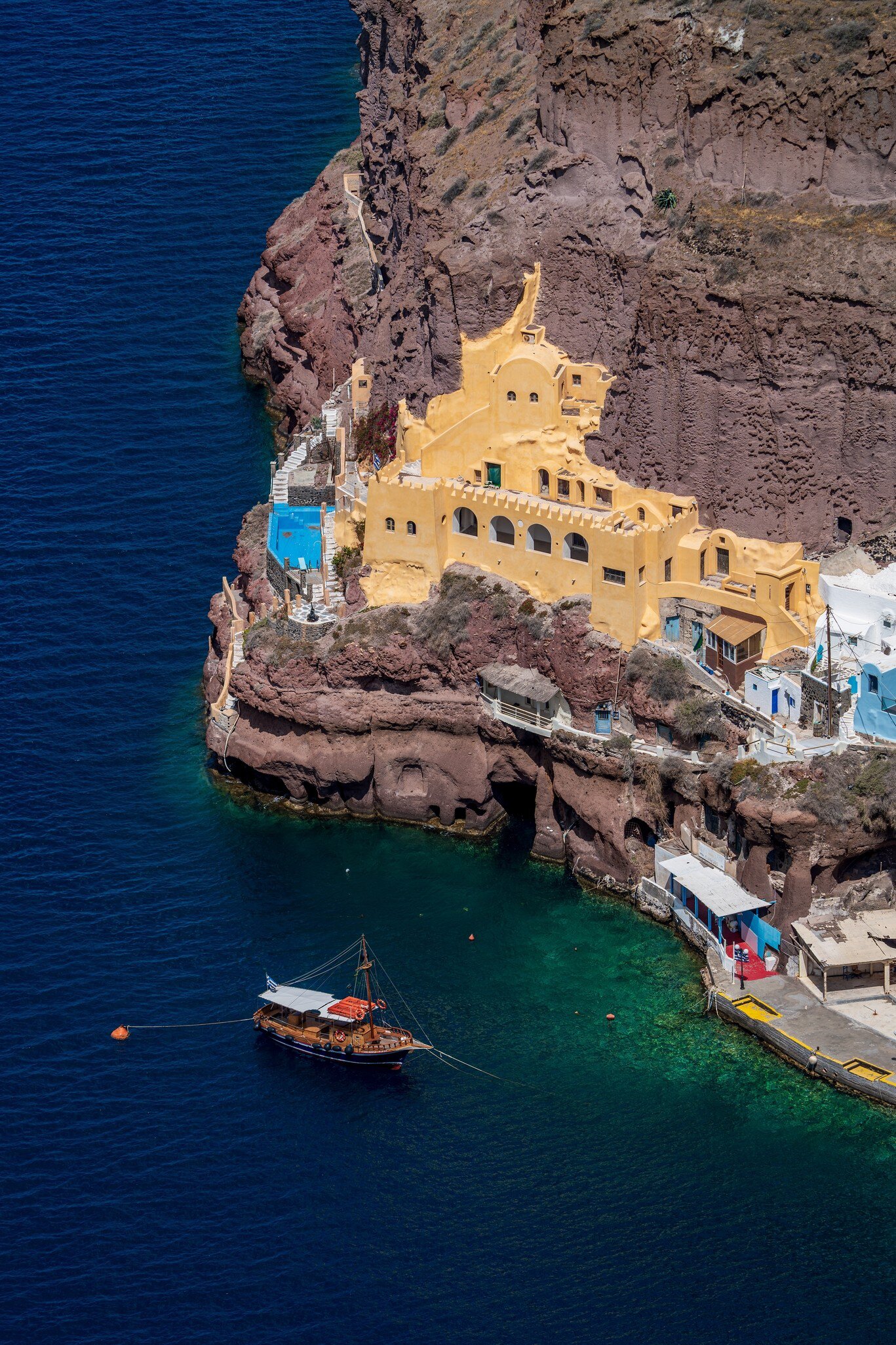 A boat sails past the port in Santorini, Cyclades, Greece