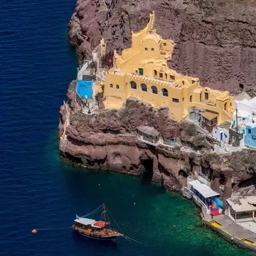 A boat sails past the port in Santorini, Cyclades, Greece