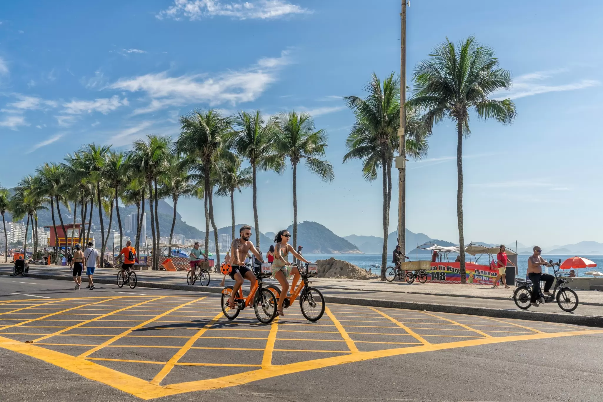 People riding bikes by the famous Copacabana Beach in the morning in Rio de Janeiro, Brazil.