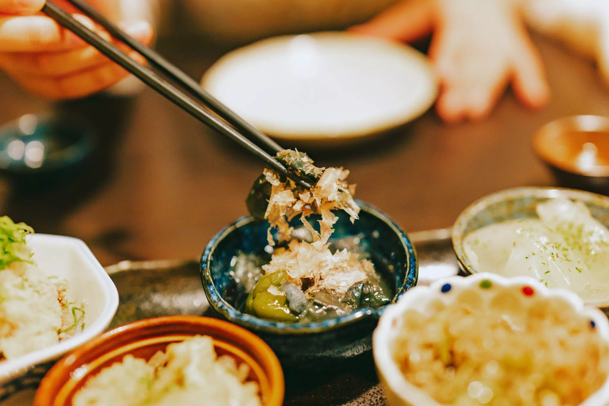 A tray with tiny round dishes each loaded with a different combination of foods and textures.