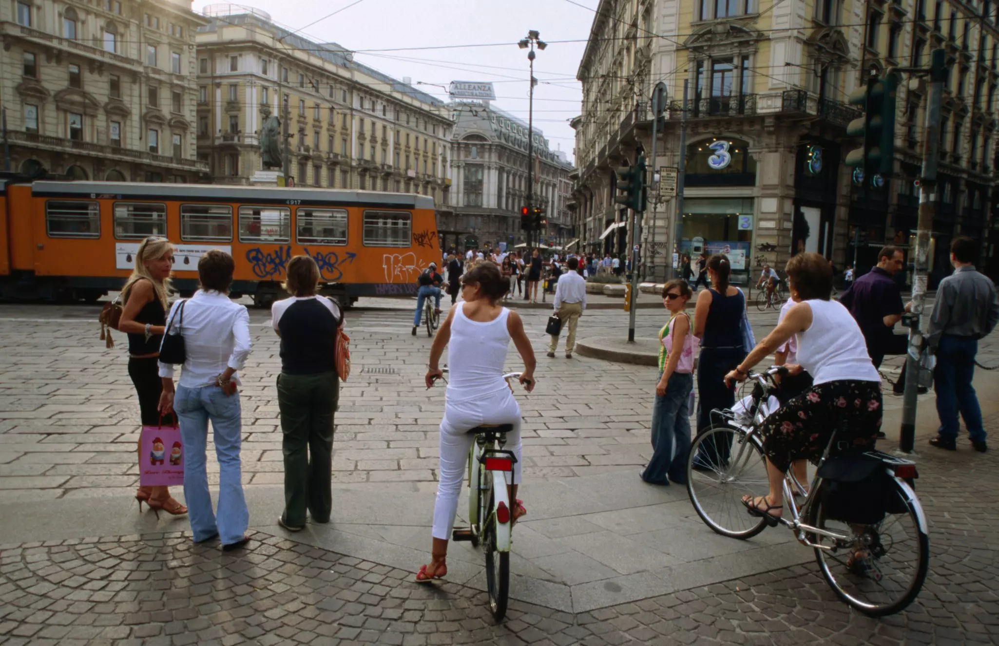 Pedestrians and cyclists on Piazza Cordusio, Milan.