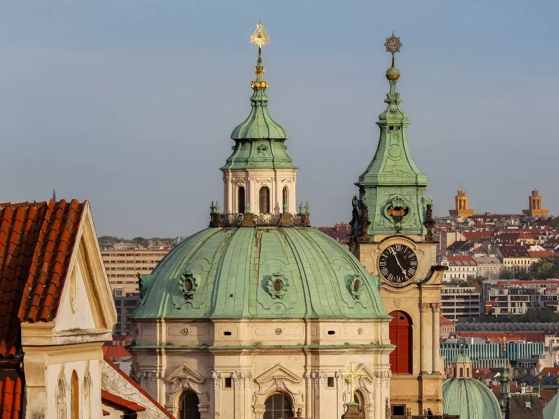 A view of the dome and bell tower of St.Nicholas Church and rooftops of Nerudova street. Prague, Czech Republic.